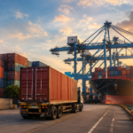 Container truck moving past a cargo ship and stacked containers at JNPA port amid container evacuation delays.