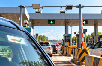 Car passing through a highway toll plaza using FASTag in India.